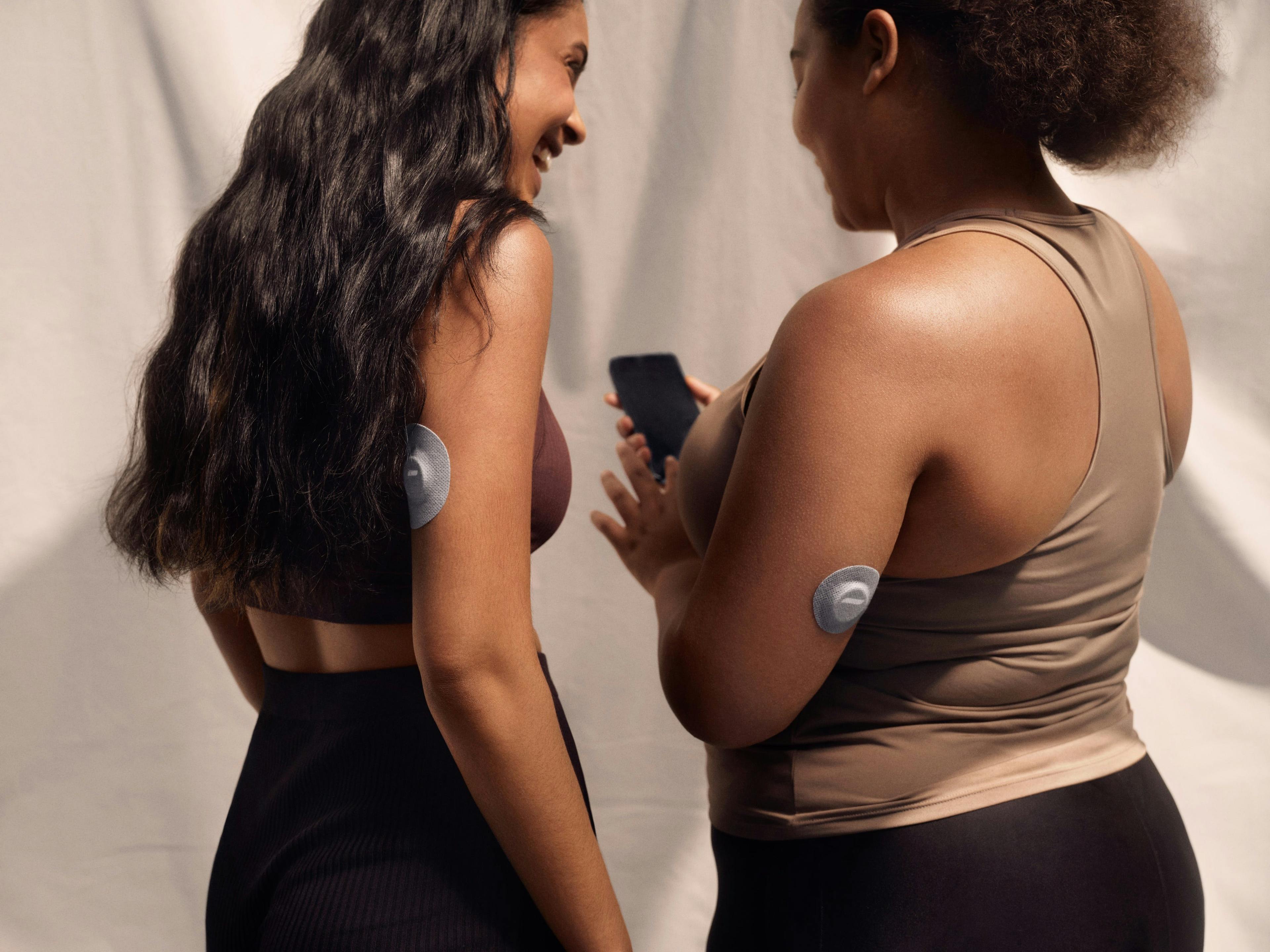 two women in athleisure tracking blood glucose levels using a cgm and the veri app