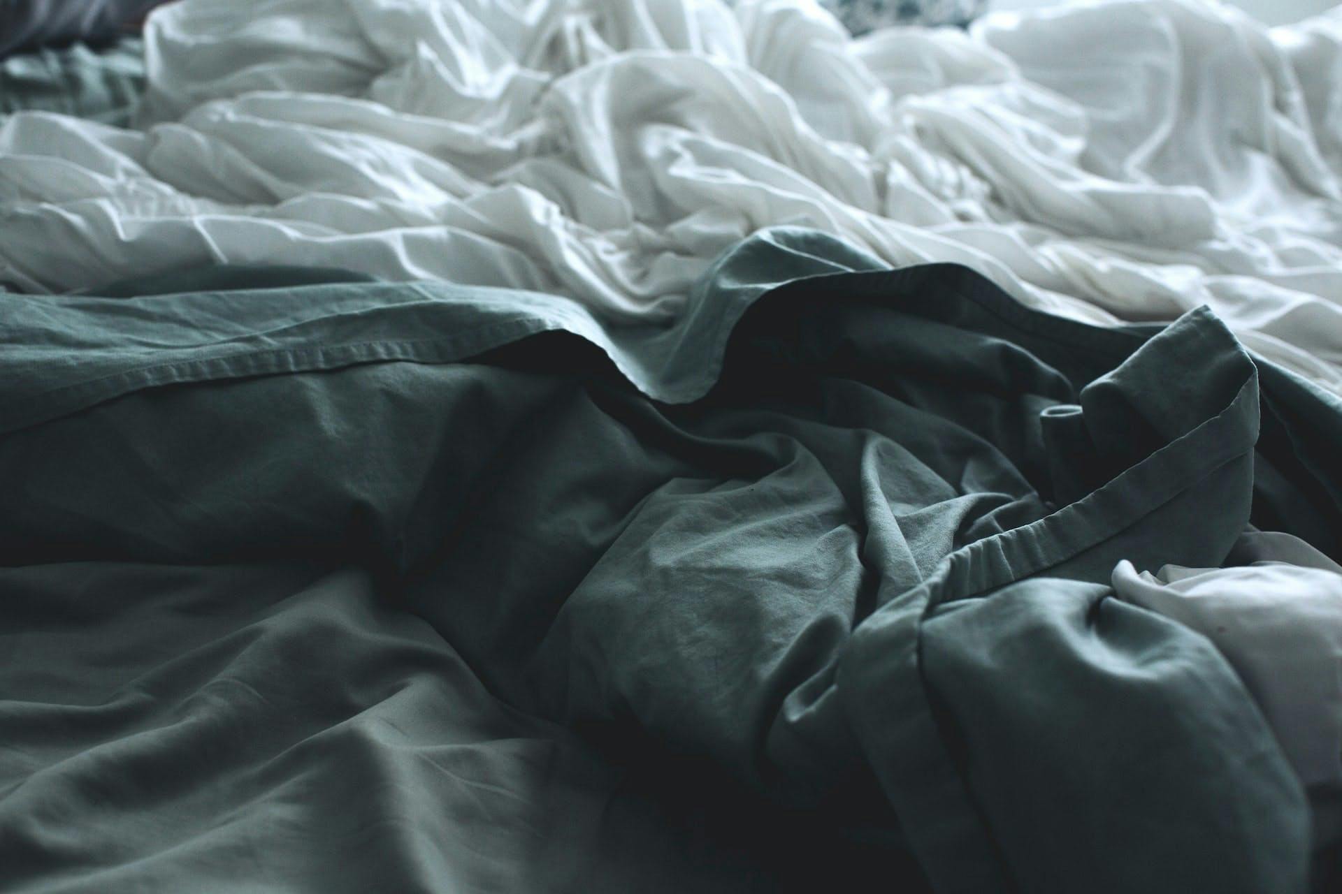 rumpled gray and white bedsheets